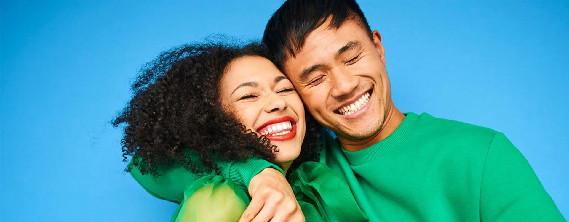 Two individuals hugging and smiling