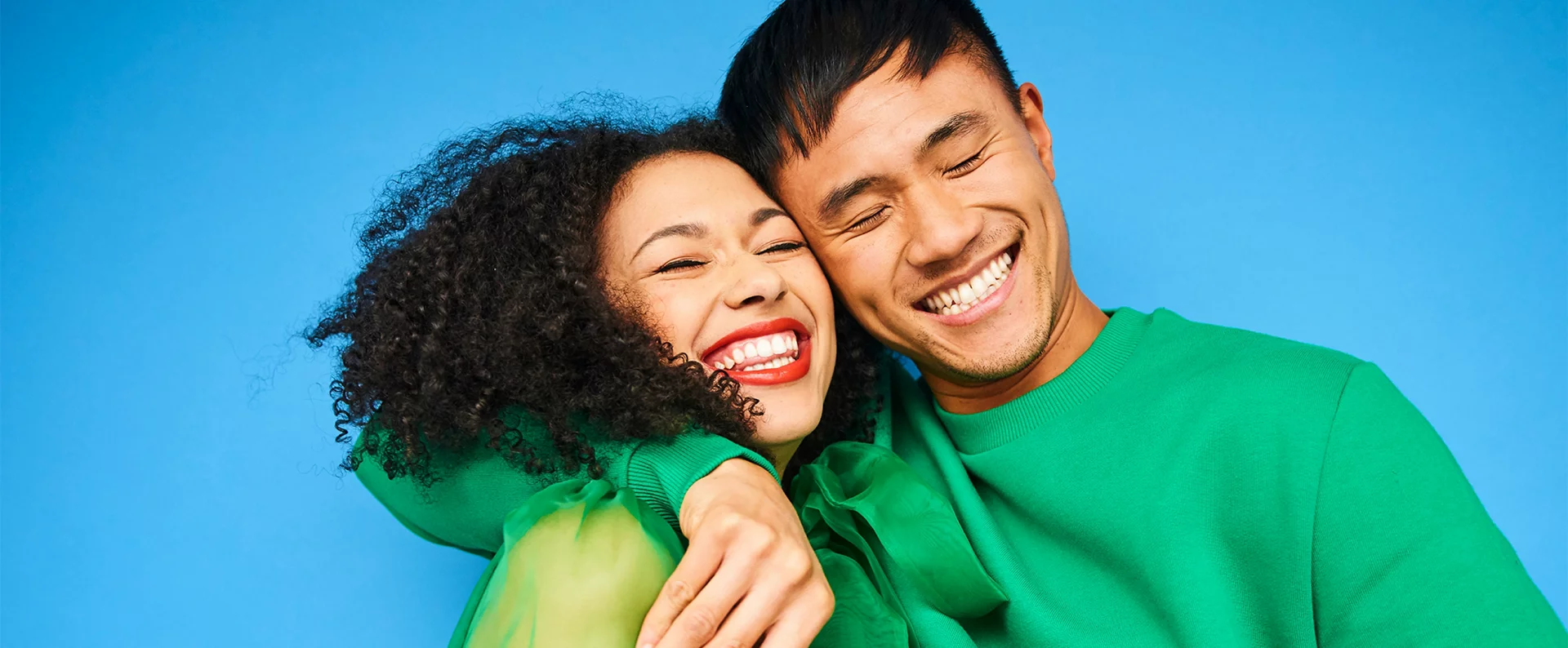 Two individuals hugging and smiling