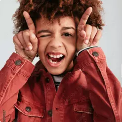Young smiling boy with finger horns