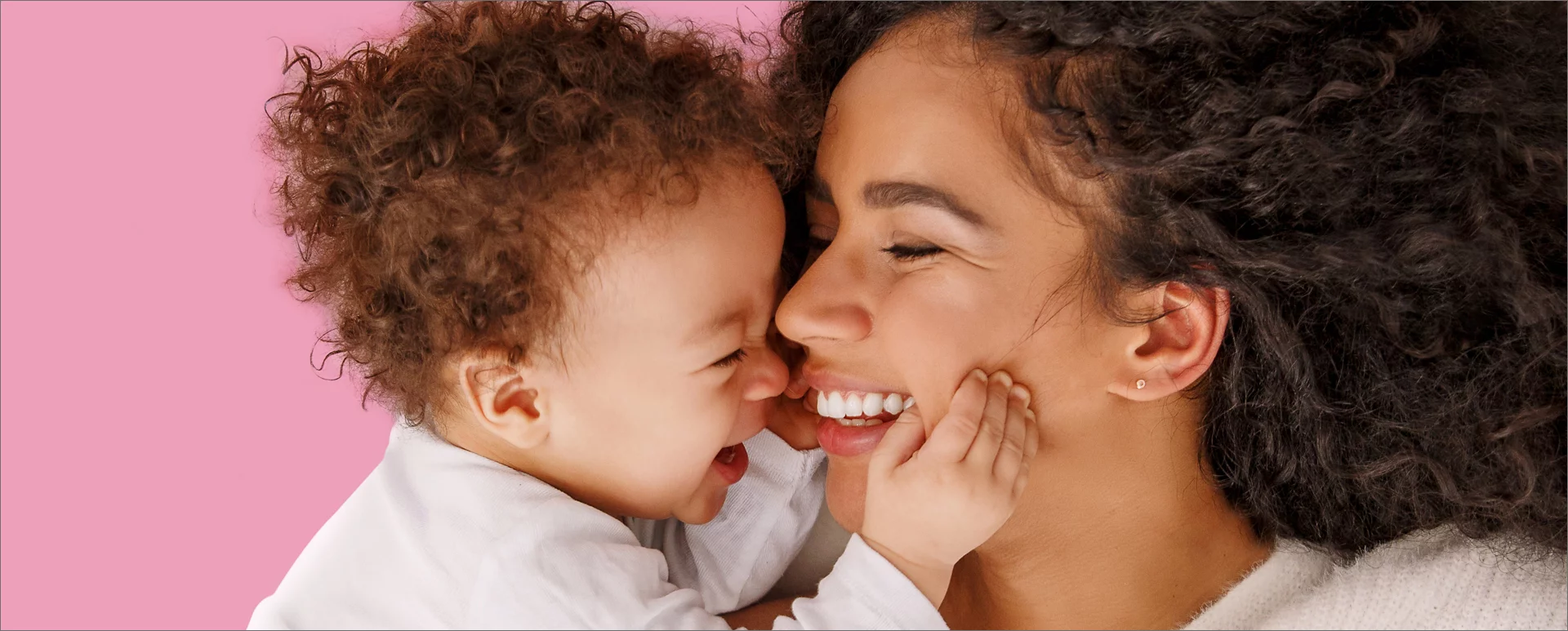 mother and her child smiling to one another while laying down.