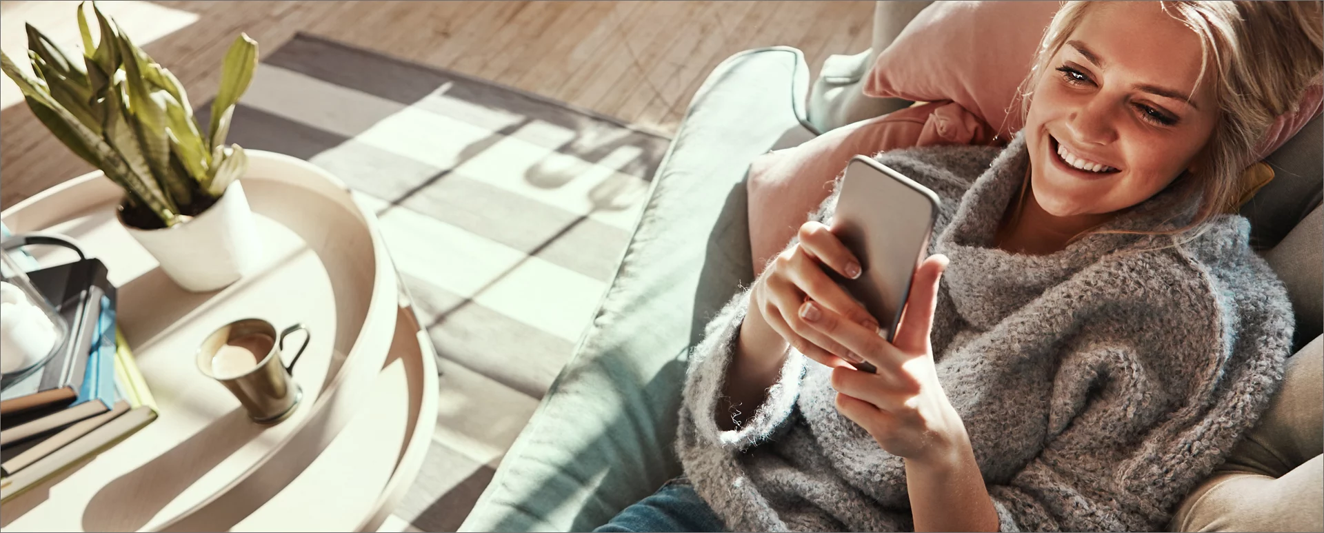 woman sitting on the couch while on her phone.
