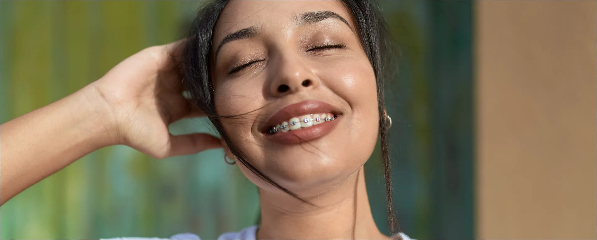Woman with braces smiling with eyes closed lifestyle photo