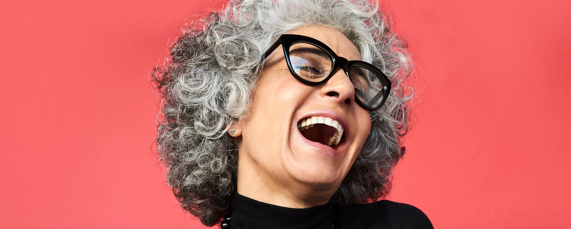 Elderly woman wearing glasses laughing