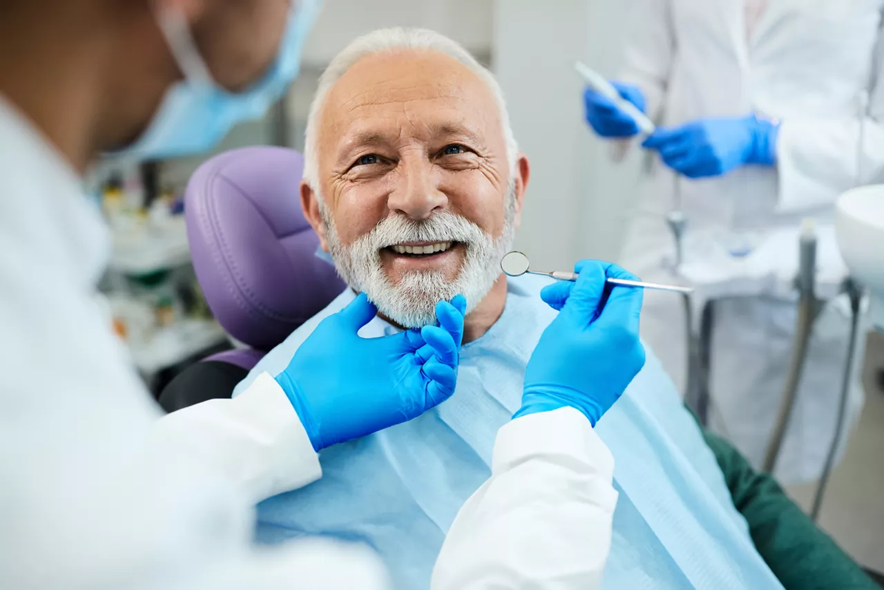 Dentist preparing to check patient with mirror