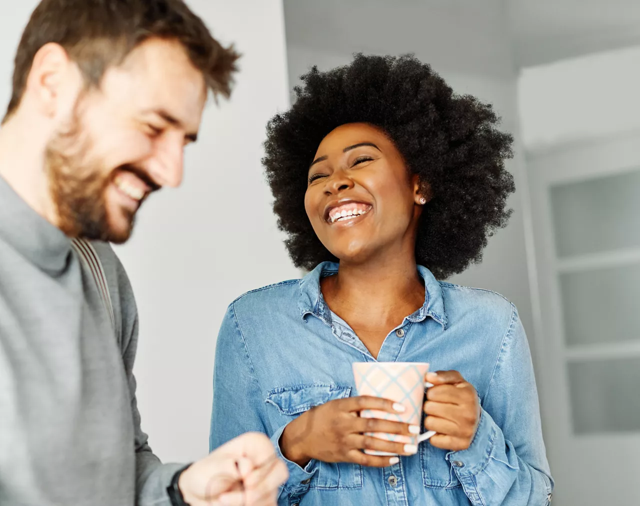 A portrait of young happy woman businesswoman or a student talking in the office or in classroom, or having a date with a boyfriend holding a cup of coffee
