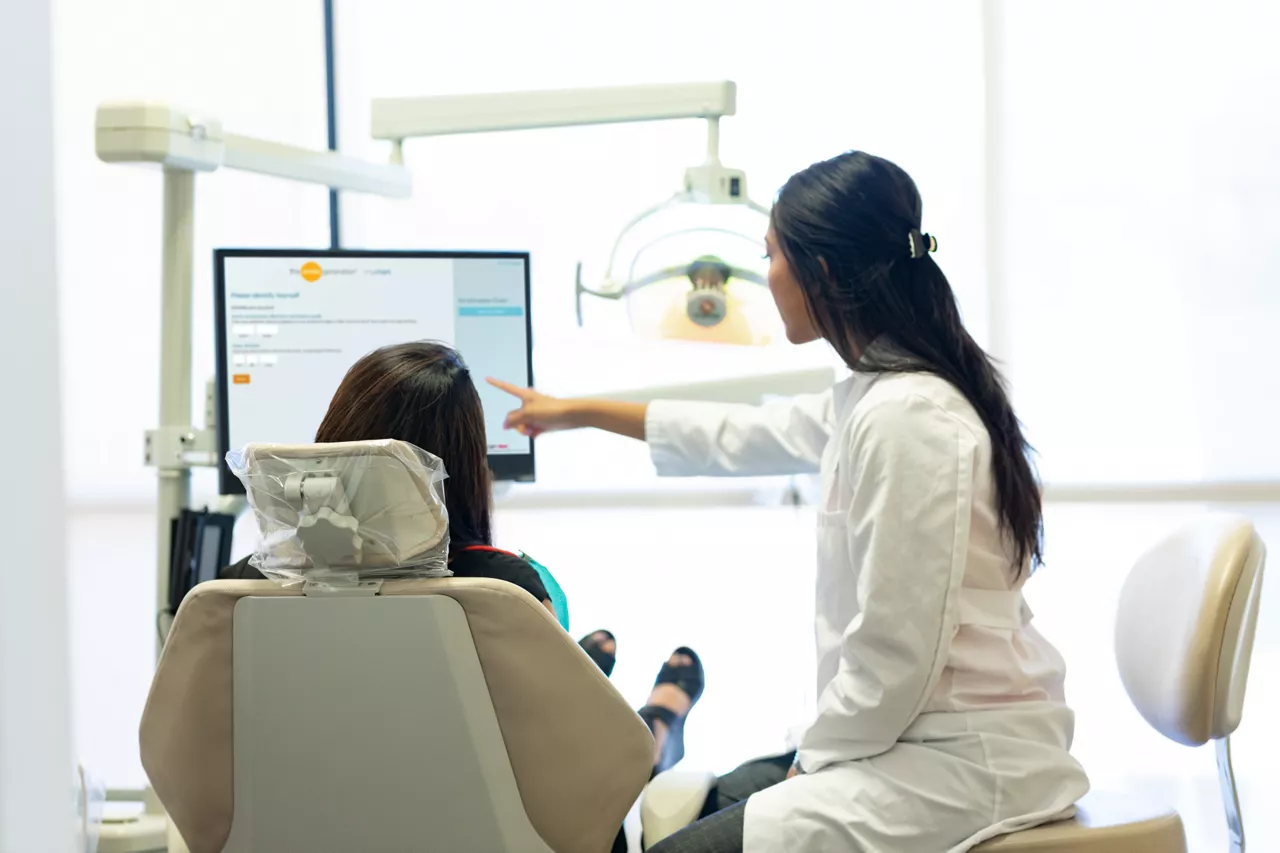 dentist showing her patient information on a screen