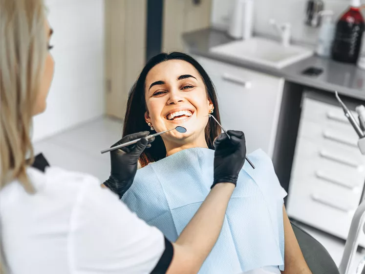 Lady smiling getting her teeth checked by dentist