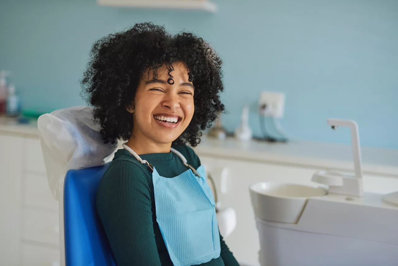 Shot of a happy young woman sitting in a dentist’s chair