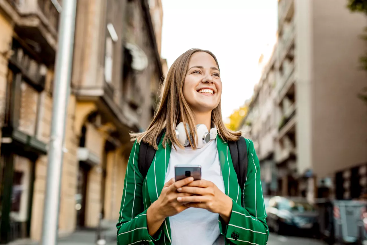 woman walking with phone and smile.