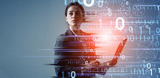 A person on a laptop while data is shown in the background