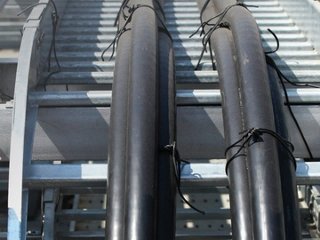 Cables and cable ties adhered to a cable ladder rack outside on a construction site facility