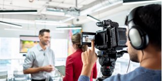 Videographer taping man and woman interview