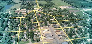 An aerial view of a rural community, with lines overlaid showing the fiber optic network for broadband