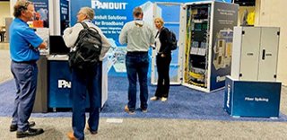 People gather in the Panduit booth at a broadband trade show