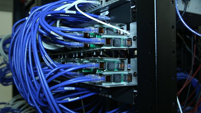 Bundle of blue network cables plugged in and being tested