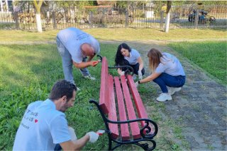 Panduit employees painting a bench