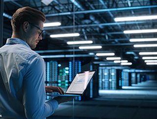 Back View of Male Specialist Using Laptop in Big Data Center Office.
