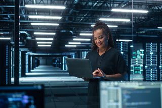 woman looking at laptop in data center
