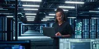 Woman on laptop inf data center