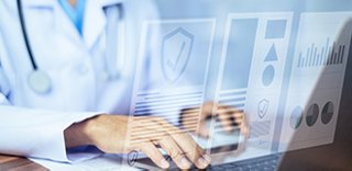Person in lab coat at a computer keyboard, with digital images of healthcare records