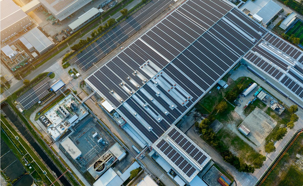 Aerial view of a solar panel factory showcasing rows of solar panels and the surrounding industrial area.