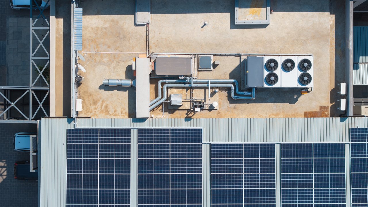  air conditioning industrial in top of a building roof, ac unit and pipe tubes with ventilation fans, solar panels