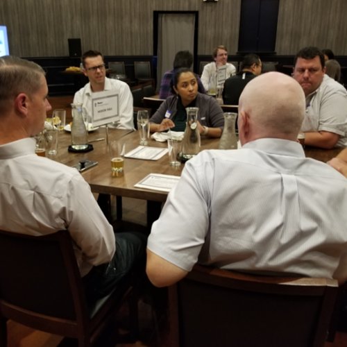 Group of people sitting around a table interacting with each other