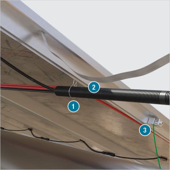 Inside of a solar power plant combiner box, showing string wires terminating and larger power cables exiting 