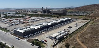 Solar Battery energy storage in a warehouse field outside with cars and construction  