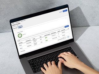 Someone typing on laptop with sustainability report on the scree