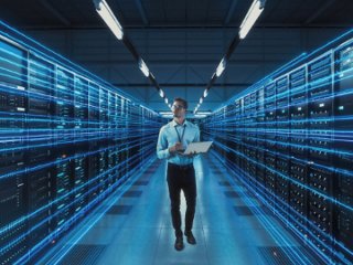 A man inspecting the server room of a data center.
