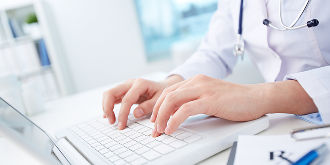 Doctor typing on computer in healthcare facility