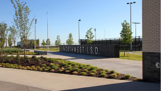 Exterior view of athletic fields at a school, with a Northwest ISD sign
