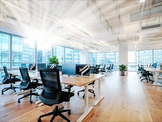 a modern open office space with lots of windows, desks, and computer monitors
