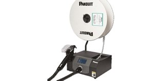 A Panduit automatic cable tie installation system with a large spool of cable ties mounted on a black base unit featuring a digital display, connected to a handheld applicator by a flexible conduit.