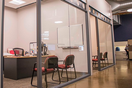 Two glass-front offices with different lighting hues through PoE lighting