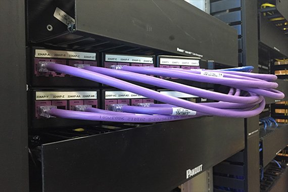 a black patch panel installed in a networking rack at purdue university