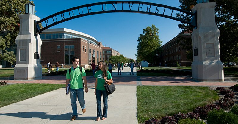 Students walking under the Purdue University archway