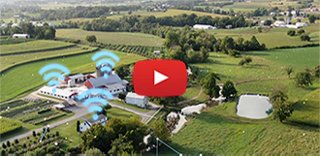 Rural farmland with houses and barns, with wireless icons overlaid