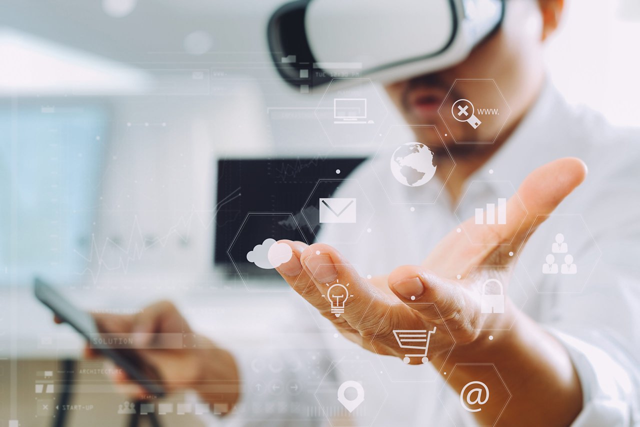 businessman wearing virtual reality goggles in modern office with mobile phone using with VR headset with VR chart and graph with icon 