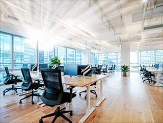 a modern open office space with lots of windows, desks, and computer monitors
