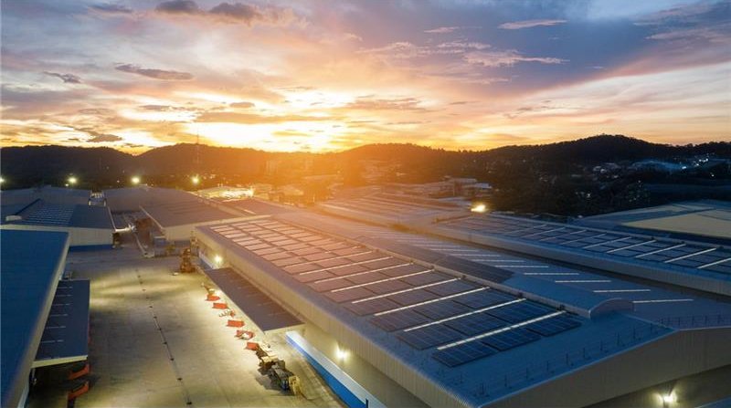 Industrial rooftop solar panels at sunset view