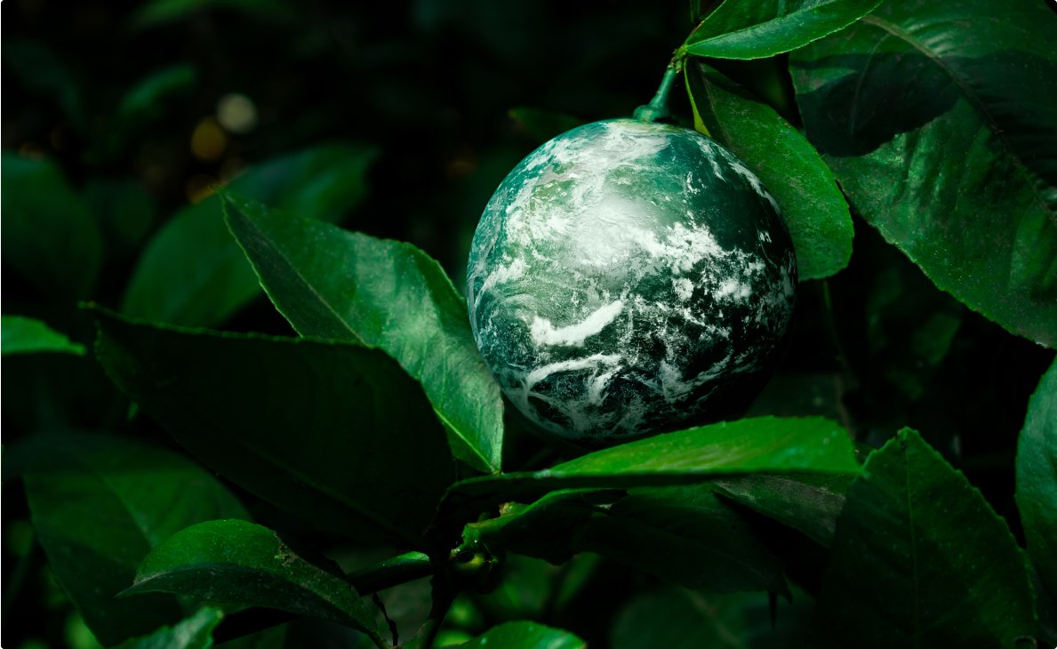 A woman and her daughter stand together, smiling in front of large wind turbines against a clear blue sky.
