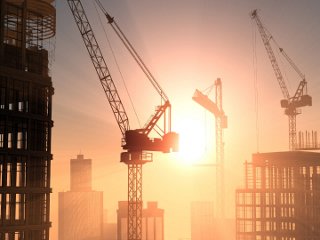 High rise buildings construction site with cranes outside sunshine