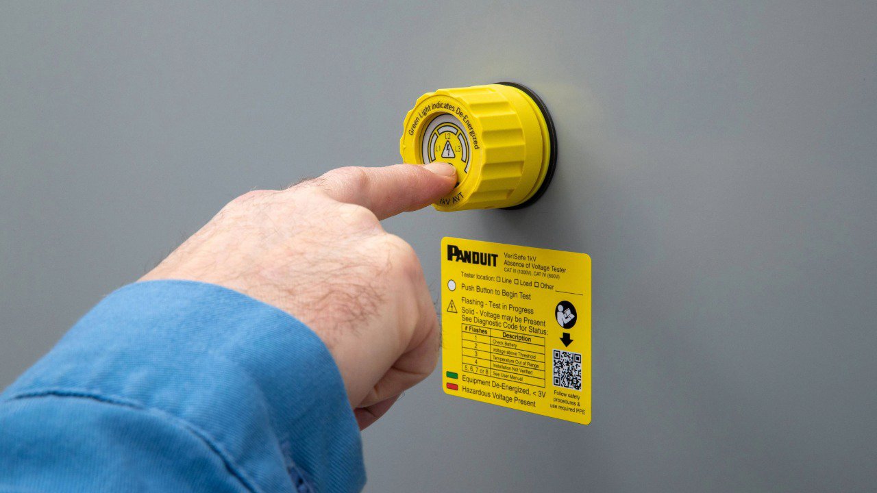 Hand of an engineer with his finger pushing the test button on a VeriSafe AVT mounted to a panel door