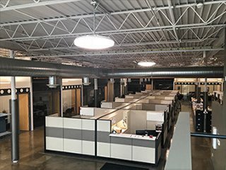 interior view of an office space with cubicle work stations and large overhead lights