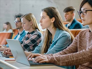 College students in a campus lecture hall with laptop computers