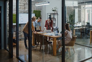 People collaborate around a table in a conference room