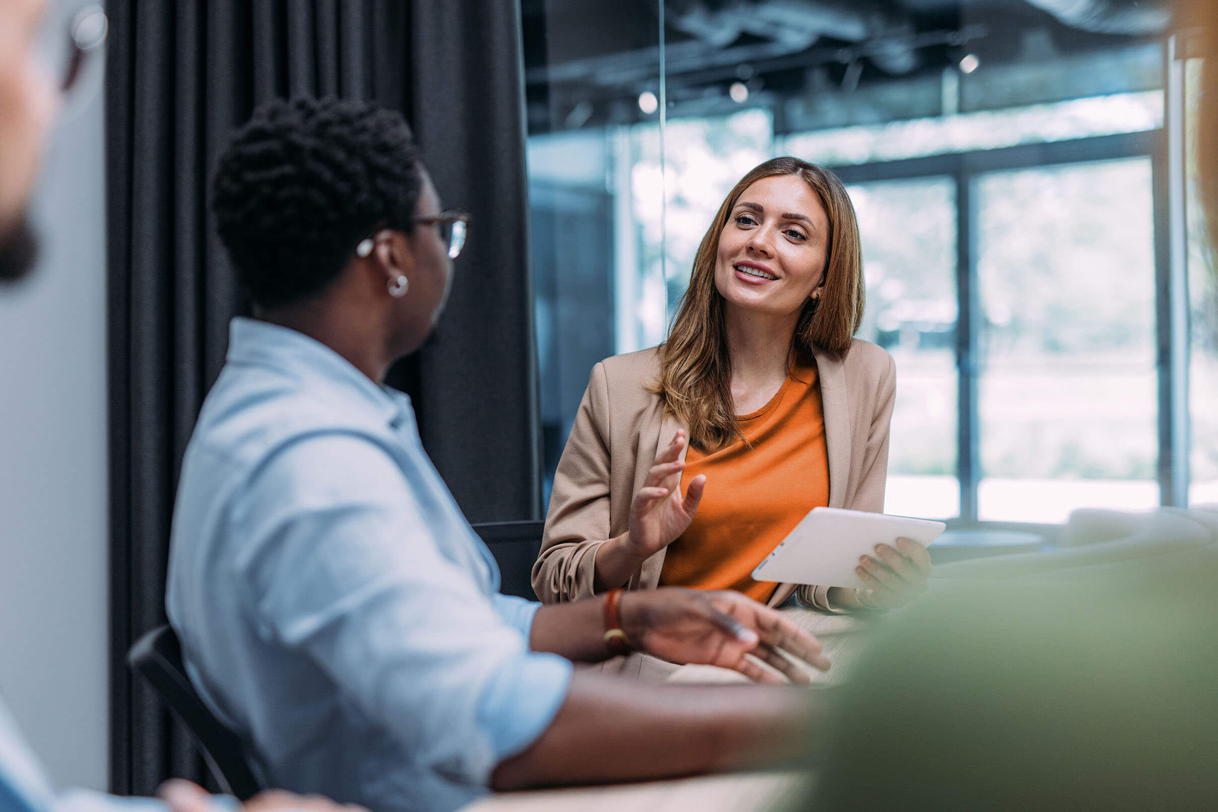 Image of two women having a conversation in workplace setting.