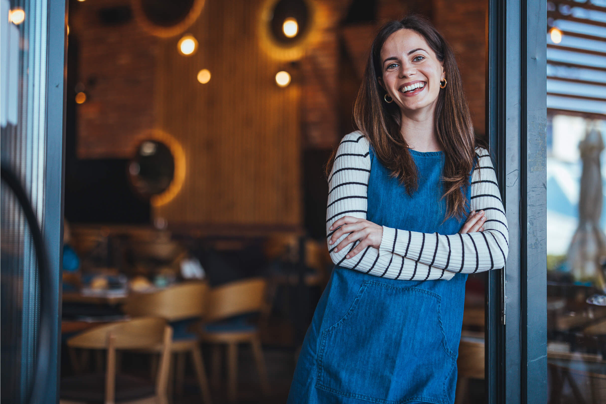 A restaurant owner looks at the camera with a smile.